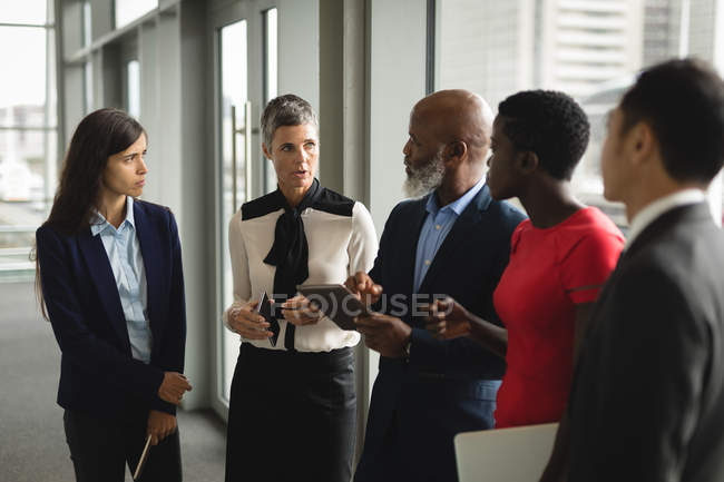 Group of serious business people having a discussion over the tablet in office — Stock Photo