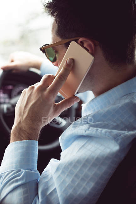 Empresario hablando por teléfono móvil en un coche moderno - foto de stock