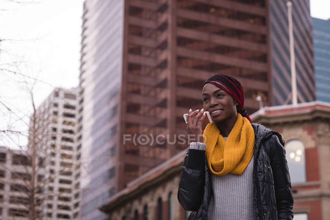 Young woman talking on mobile phone in city street — Stock Photo