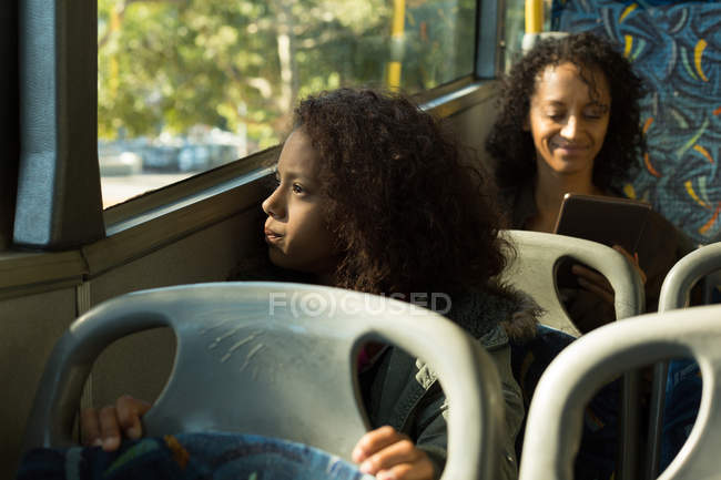 Дівчина-підліток дивиться крізь вікно під час подорожі в автобусі — стокове фото