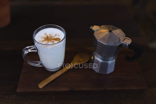 Milk and coffee kettle served on a wooden board at a coffee shop — Stock Photo