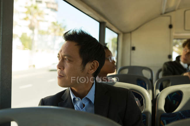 Homme regardant par la fenêtre tout en voyageant dans le bus — Photo de stock