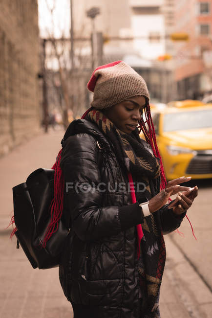 Jovem usando telefone celular na rua da cidade — Fotografia de Stock