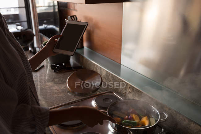 Женщина готовит овощи на кухне дома — стоковое фото