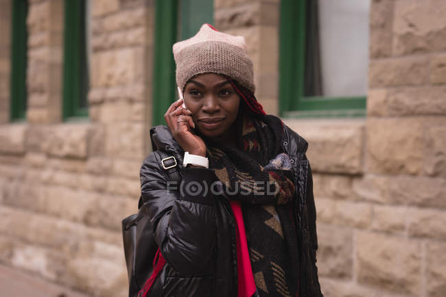 Mujer joven hablando por teléfono móvil en la calle de la ciudad - foto de stock