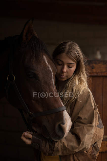 Teenager-Mädchen streichelt ein Pferd auf der Ranch — Stockfoto