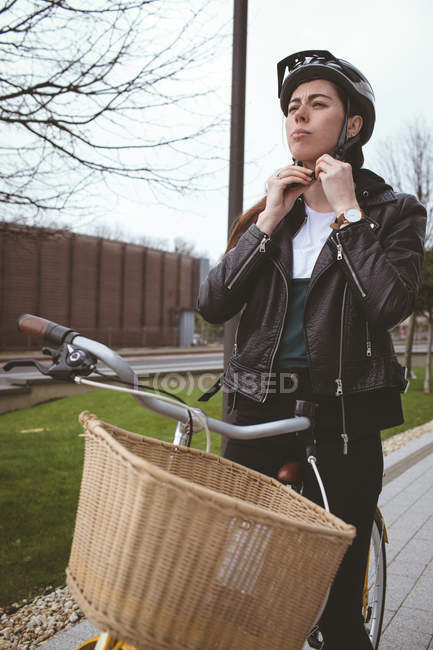 Belle femme à vélo portant un casque — Photo de stock