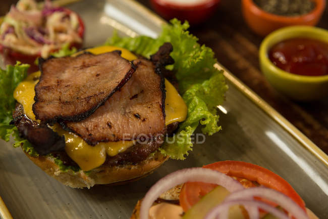 Primer plano de la hamburguesa de carne servida en bandeja - foto de stock