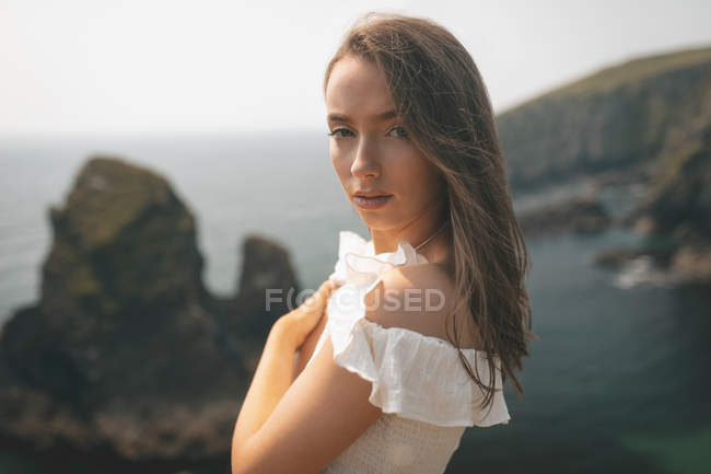 Retrato de mulher bonita de pé perto do mar em um dia de brisa — Fotografia de Stock