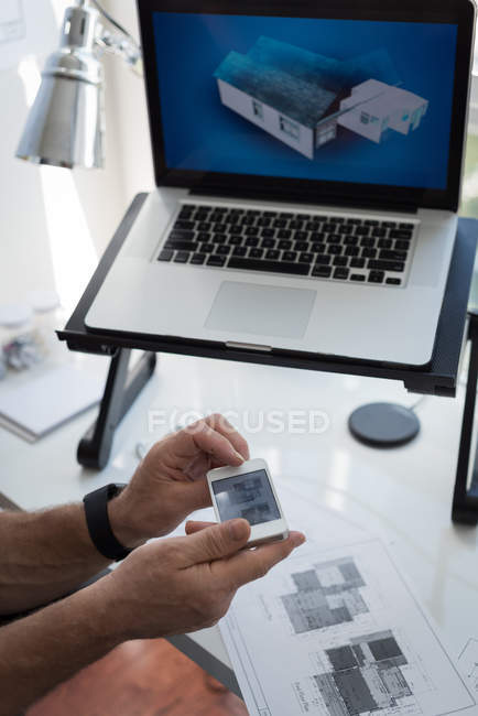 Man using mobile phone while preparing architectural design at home — Stock Photo