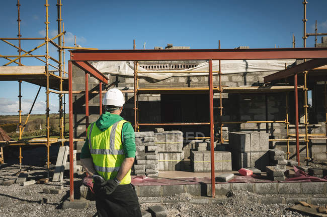 Вид спереду інженера, який дивиться на забудовану будівлю — стокове фото