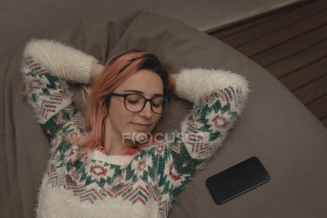 Junge Frau ruht sich im Café auf einem Bohnensack aus — Stockfoto