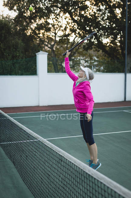 Пожилая женщина, играющая в теннис на теннисном корте — стоковое фото