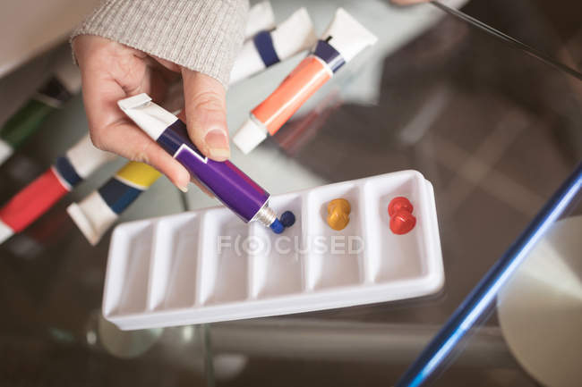 Primo piano della donna che utilizza il colore del tubo a casa — Foto stock