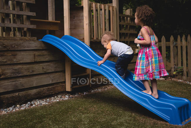 Geschwister spielen an einem sonnigen Tag im Garten — Stockfoto
