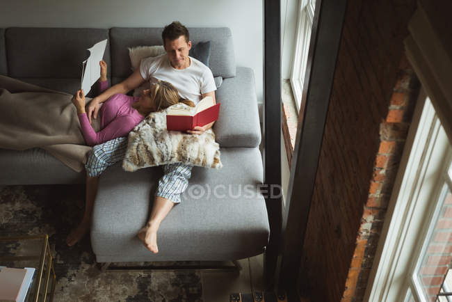 Casal leitura de livros na sala de estar em casa — Fotografia de Stock