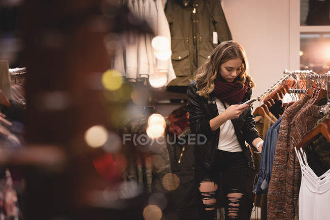 Красива дівчина використовує мобільний телефон під час покупки в торговому центрі — стокове фото