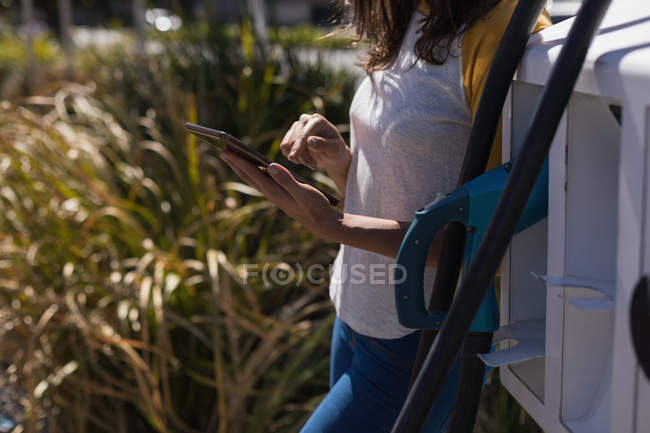 Середина жінки, що використовує цифровий планшет на зарядній станції — стокове фото
