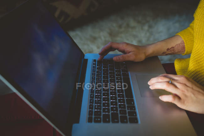Mid section of woman using laptop at home — Stock Photo