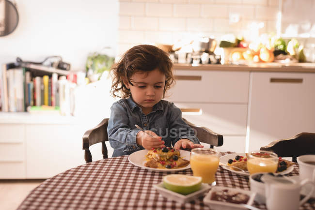 Kleines Mädchen frühstückt zu Hause in der Küche. — Stockfoto