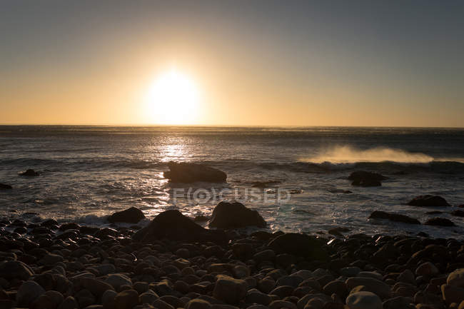Beau coucher de soleil sur le rivage rocheux — Photo de stock