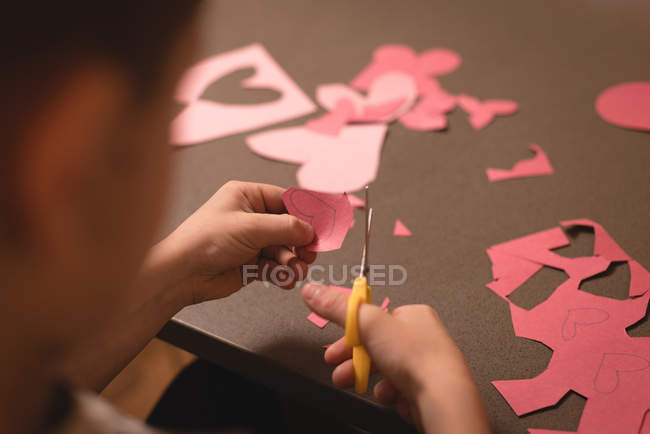 Niño preparando tarjeta de San Valentín en casa - foto de stock