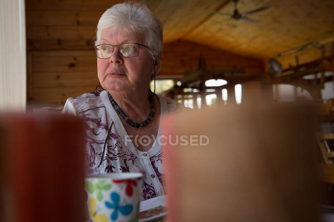 Задумчивая пожилая женщина отдыхает в магазине — стоковое фото