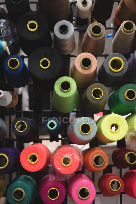 Gros plan fils multicolores disposés en rangée dans le magasin de tailleur — Photo de stock