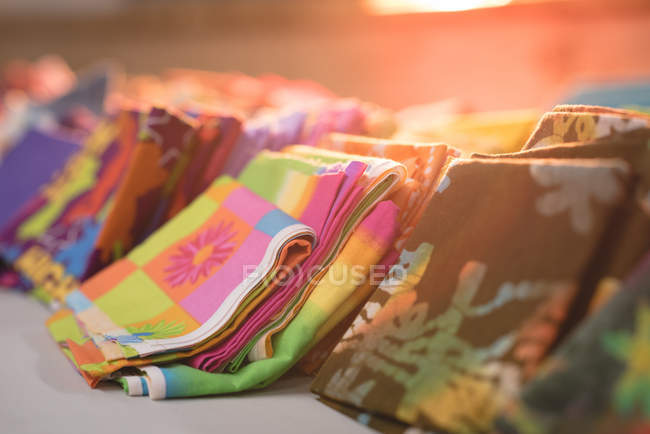 Крупним планом різні кольорові тканини розташовані в ряд в крамниці кравець — стокове фото