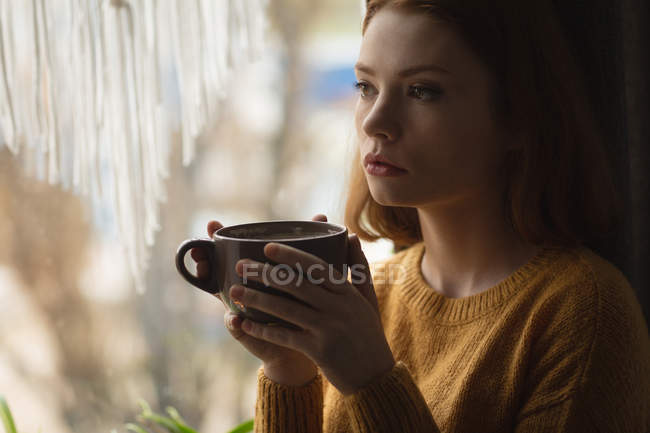Thoughtful woman having coffee at home — Stock Photo