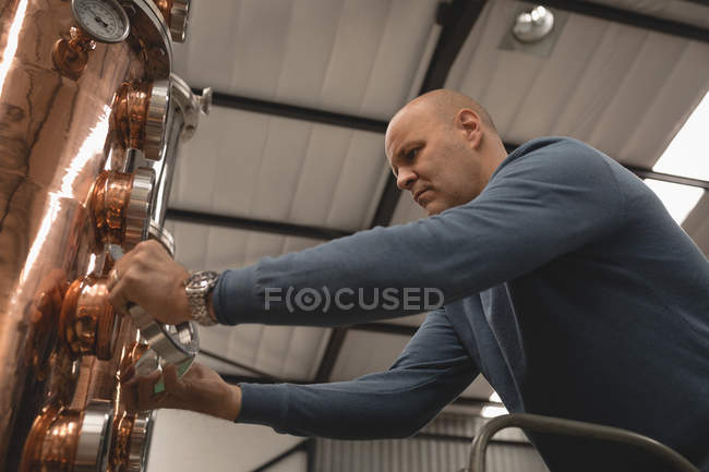 Macchina di controllo operaia maschile della distilleria in fabbrica — Foto stock