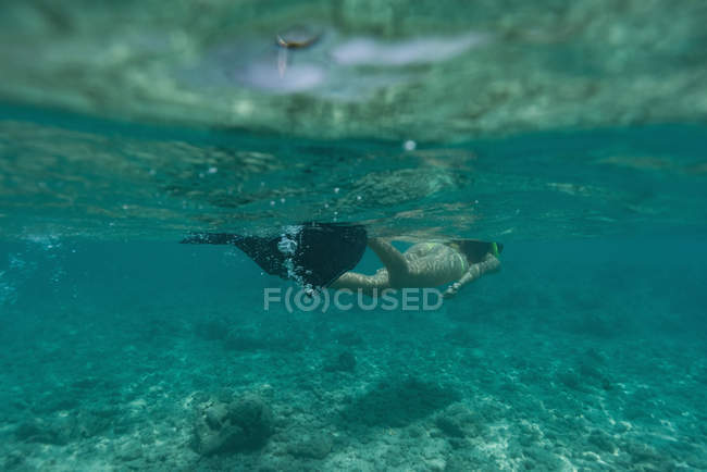 Жінка хропіння під водою в бірюзовому морі — стокове фото
