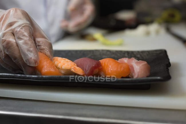 Chef sosteniendo comida de mar en la cocina del hotel - foto de stock