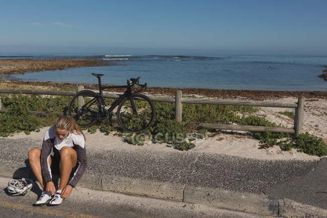 Motociclista usando su zapato de encaje en un día soleado - foto de stock