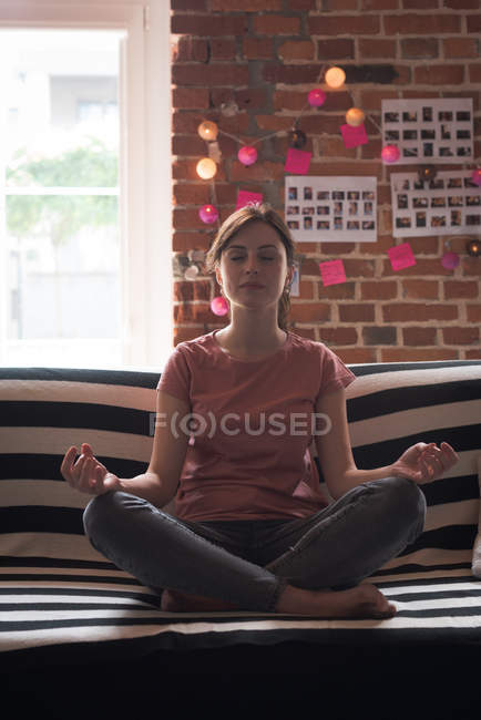 Joven ejecutiva realizando yoga en oficina - foto de stock