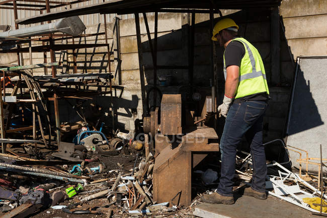 Trabalhador trabalhando em scrapyard em um dia ensolarado — Fotografia de Stock