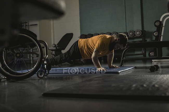 Handicapped man doing pushup on mat in gym — Stock Photo
