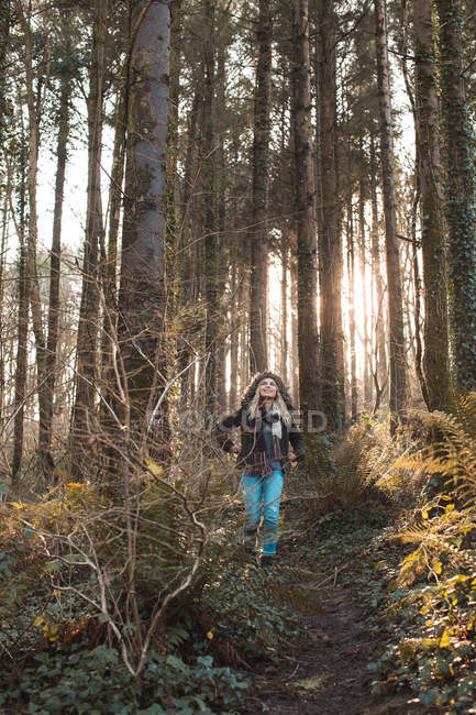 Женщина, гуляющая в лесу в солнечный день — стоковое фото