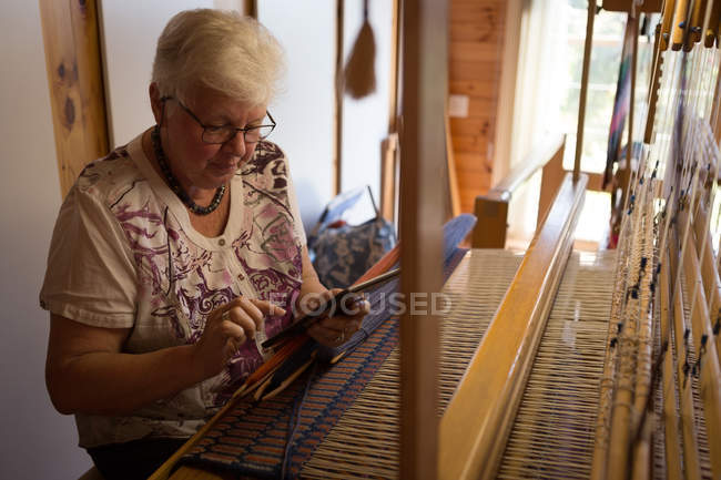 Active senior woman using digital tablet at shop — Stock Photo