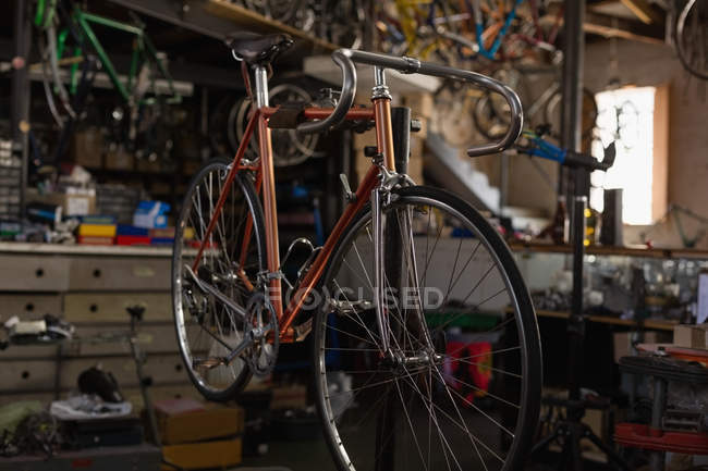 Bicicleta de carreras colgando en taller - foto de stock