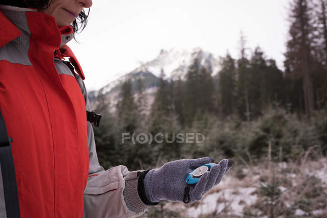 Mid section of woman looking at compass while hiking — Stock Photo