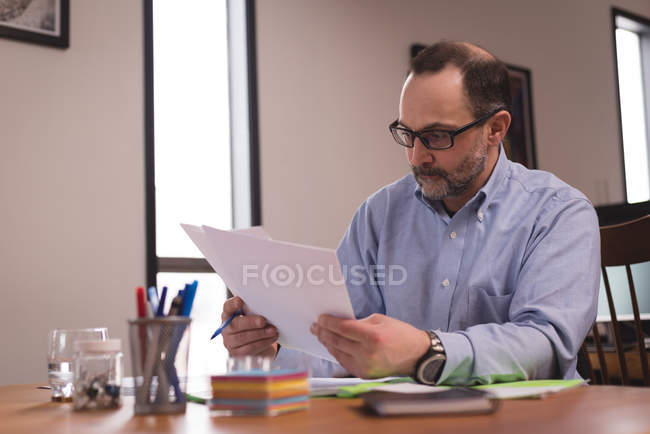 Männliche Führungskraft schaut sich Dokumente im Amt an — Stockfoto