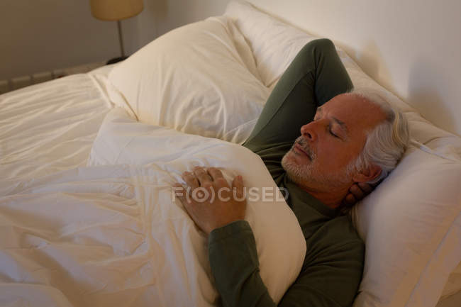 Пенсионер спит в спальне дома — стоковое фото
