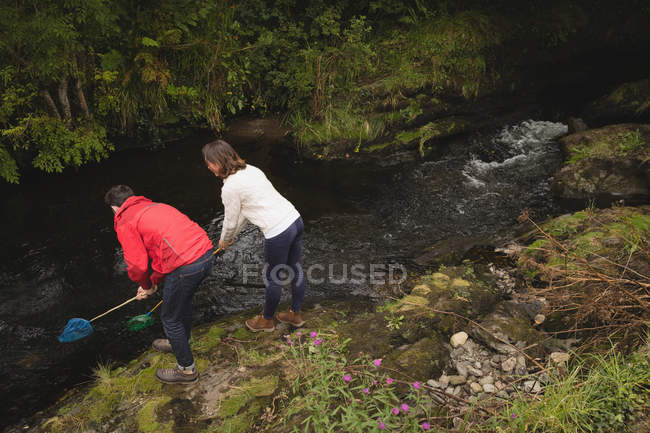 Пара риболовля з сіткою в річці в сільській місцевості — стокове фото
