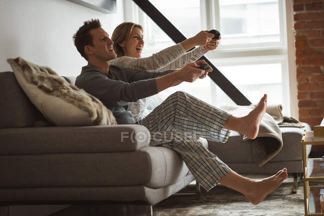 Casal jogando jogos de vídeo na sala de estar em casa — Fotografia de Stock