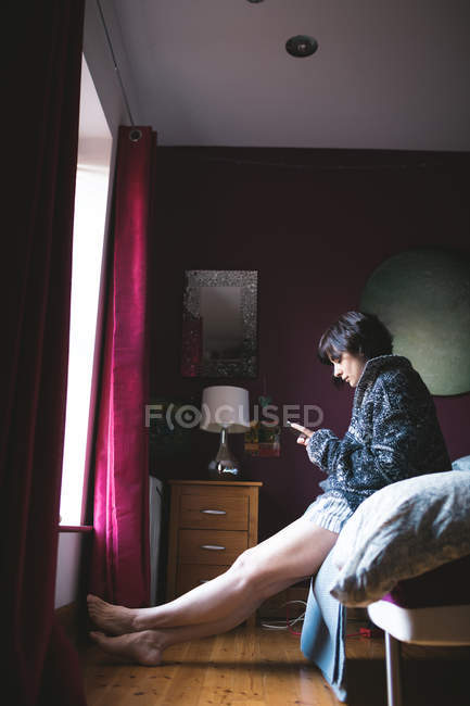 Frau benutzt Handy zu Hause im Schlafzimmer — Stockfoto
