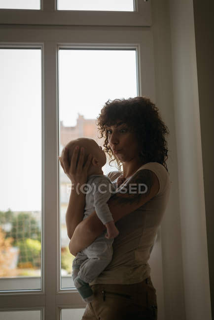 Mère jouant son bébé à la maison — Photo de stock