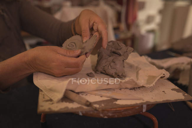 La sezione media di vasaio femminile che modella un'argilla a casa — Foto stock