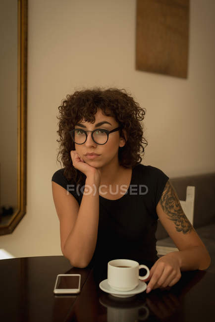Mujer pensativa tomando café en casa - foto de stock