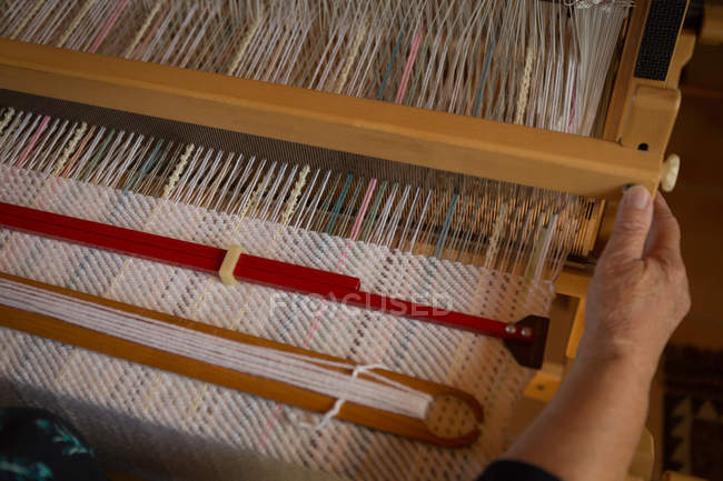 Close-up de seda de tecelagem de mulher sênior na loja — Fotografia de Stock